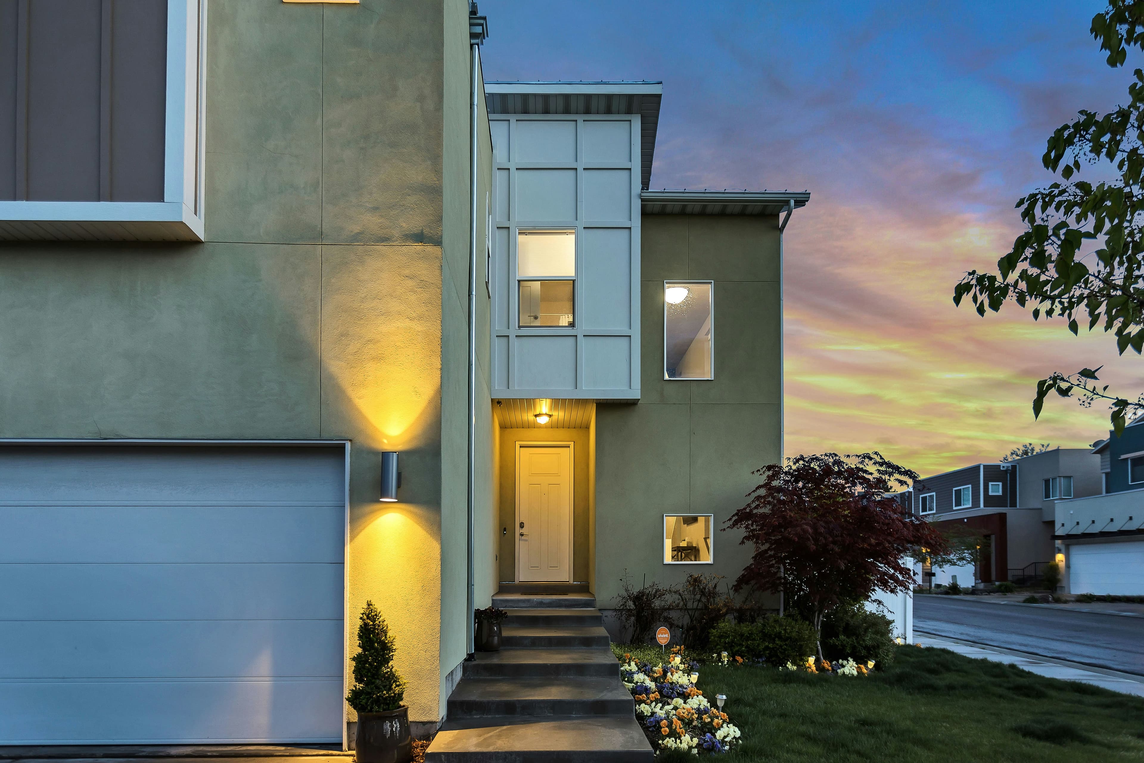 Modern home exterior lit up at dusk